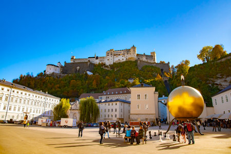 Kapitelplatz square with a sculpture of a man on a golden sphere in Salzburg City. Taken in Salzburg, Austria, October 20, 2016のeditorial素材