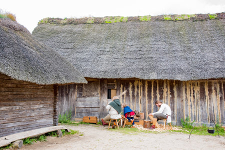 Actors dressed in middle age viking attires and performing daily activities of viking villagers in Viking Haithabu village. Taken in Busdorf, Germany on July 15, 2016のeditorial素材
