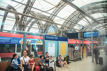 Passengers waiting for a train at the railway platform of Dresden Hauptbahnhof which is the largest passenger station in the Saxon capital of Dresden. Taken in Dresden, Germany on July 22, 2016のeditorial素材