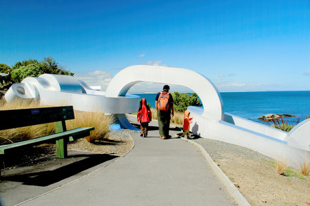 Family of Asian tourists visiting a giant anchor chain artwork sculpture in Bluff, New Zealand on Nov 30, 2010のeditorial素材