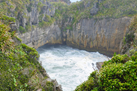 The Pancake Rocks at Dolomite Point near Punakaiki are a heavily eroded limestone area where the sea bursts through several vertical blowholes. Punakaiki, New Zealand on Dec 7 2010のeditorial素材