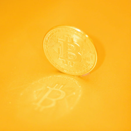 Bitcoin against golden background with reflections. Cryptocurrency concept.