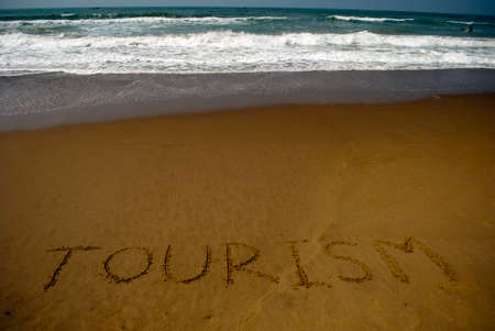 Travel written on sandy beach near seaの写真素材