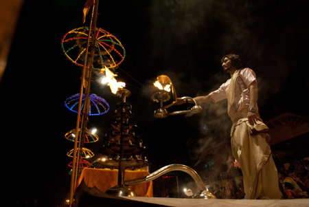 A Hindu Brahmin priest is leading a night prayer ceremony on the Ganges River Ghats in Varanasi, India.のeditorial素材