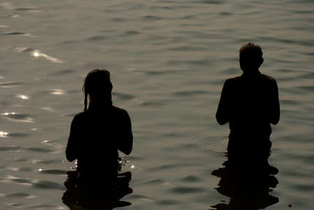 A couple of Indian Hindu men are worshiping river Ganges after taking bath with meditation on the river Ganges at Varanasi, India.のeditorial素材