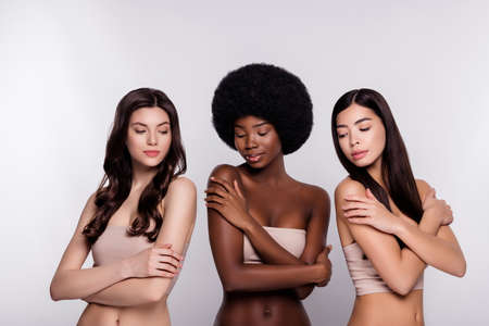 Photo of three young woman happy positive smile enjoy bodycare lotion isolated over grey color backgroundの写真素材