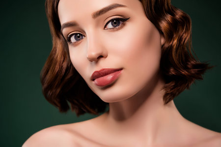 Portrait of young gorgeous stunning female naked shoulders perfect silky skincare isolated on green color backgroundの写真素材