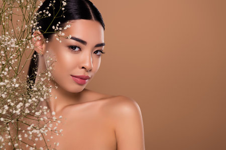 Photo of adorable gentle lady organic floral nourishing cream lotion empty space isolated on beige color backgroundの写真素材