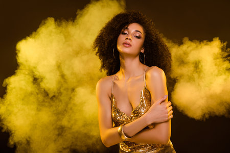 Portrait of sensual lovely girl embrace self dressed trendy elegant golden outfit isolated on brown color backgroundの写真素材