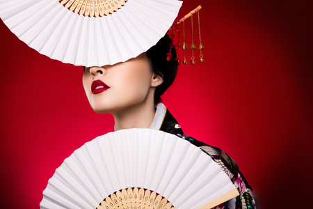 Photo of glamour indonesia lady geisha dressed costume tea ceremony festival isolated on red gradient color backgroundの写真素材