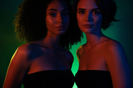 Photo of gorgeous two girls bachelorette celebrate prom event in modern disco discotheque with green neon effectの写真素材