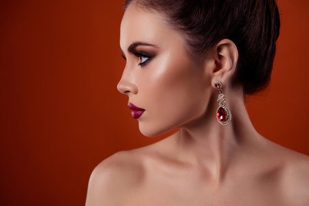 Profile photo of romantic rich lady wearing expensive gems earrings look copy space isolated on red color backgroundの写真素材