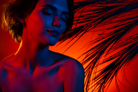 Photo of shiny adorable woman naked shoulders enjoying tropical resort sunset isolated red neon color backgroundの写真素材