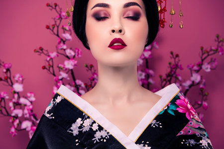 Portrait of a stunning elegant korean woman geisha character with ideal perfect maquillage over pink color backgroundの写真素材