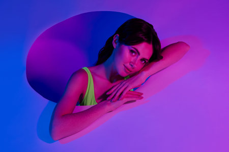 Photo of girl lean pink neon placard from circle hole isolated vivid color background