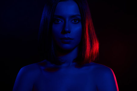 Photo of attractive girl look camera isolated neon blue light dark backgroundの写真素材