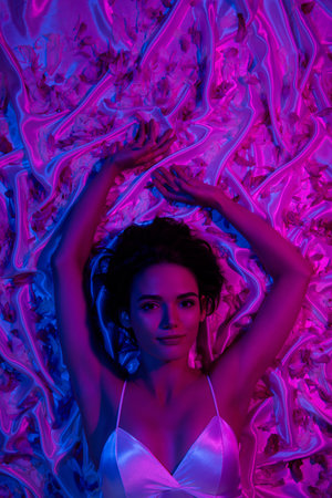 Vertical photo of lady lying down raised arms up sleeping in bedroom romantic honeymoon over neon petals backgroundの写真素材