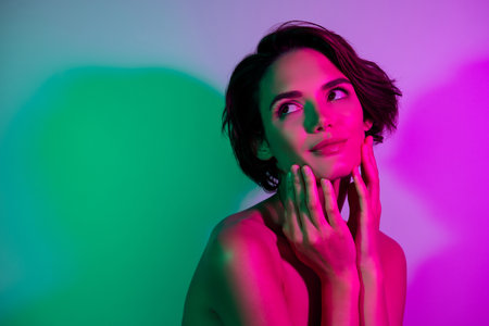 Photo of pretty girl touch face skin look empty space isolated gradient vivid color backgroundの写真素材