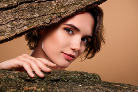 Cropped photo of charming feminine lady enjoying natural bark essence isolated beige color backgroundの写真素材