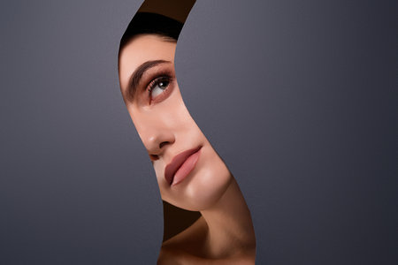 Photo of magnificent attractive model looking promo banner empty space isolated on grey color backgroundの写真素材