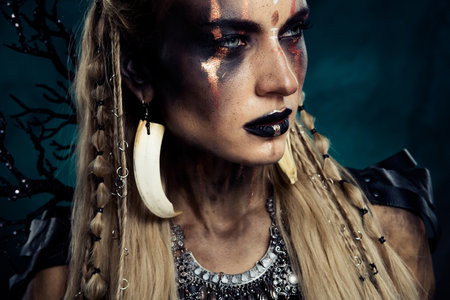 Photo of viking tribal leader lady wear traditional jewel for night ritual magic in scary woods over mist backgroundの写真素材