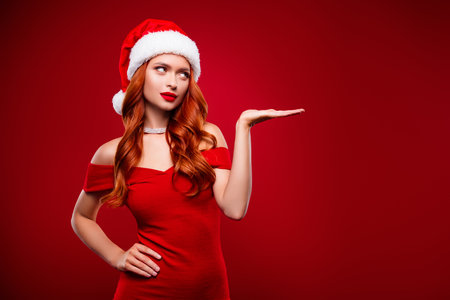 Photo of attractive wealthy luxurious girl hold hand demonstrate red color background empty space for new year adsの写真素材