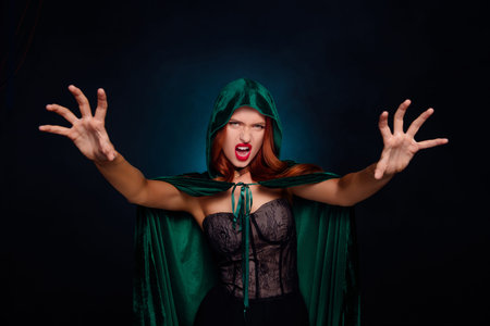 Photo of powerful evil witch raise hands claws like doing magical speel isolated black color...