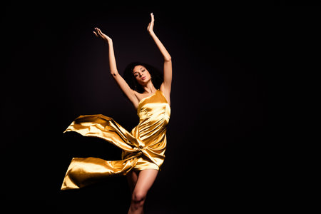 Photo of carefree adorable lady dressed gold outfit enjoying ballet dance isolated black color backgroundの写真素材