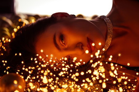 Pphoto of stunning lady lying on shiny backdrop covered decorated with xmas garlands lights
