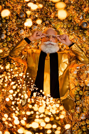 Top view photo of cool attractive grandfather prepare new year celebration touch spectacles lying balls decor sparksの写真素材