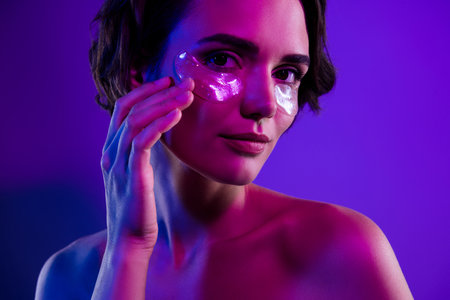 Photo of attractive girl touch face apply collagen eye pads isolated gradient vivid color backgroundの写真素材