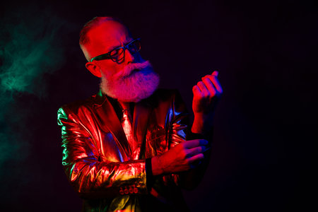 Photo of confident man in stylish outfit fasten cufflinks prepare celebration isolated on dark neon color backgroundの写真素材