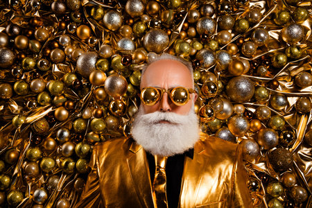 Top view photo of cool serious man in foil style color suit outfit put christmas tree ball eyes lying festive decorの写真素材