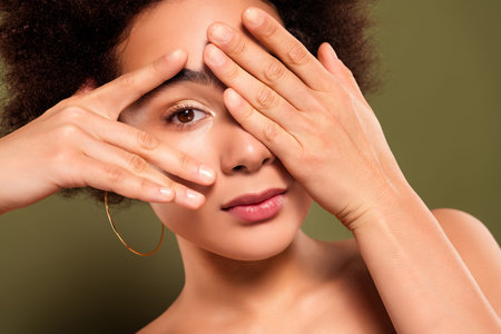 Close up photo of pretty charming lady hand cover eye salon procedure isolated on khaki color...