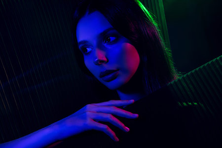 Portrait of a young woman with vibrant neon lighting showcasing beauty, style, and elegance in a...