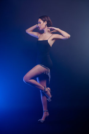 Full length photo of stunning shiny lady dressed in an elegant outfit enjoying ballet dance isolated on a blue backgroundの写真素材