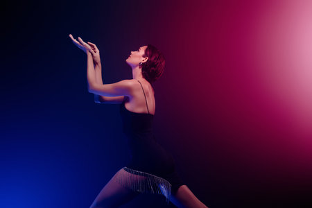 Photo of lady wear black dress dancing moves isolated dark blue pink color backgroundの写真素材