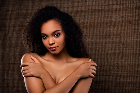 Elegant young woman with natural beauty in subtle lighting showing delicate expression and confidenceの写真素材