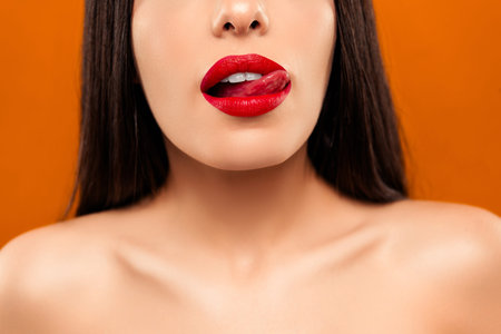 Close up of a Young Woman with Red Lips Against a Vivid Orange Background, Exuding Elegance and...