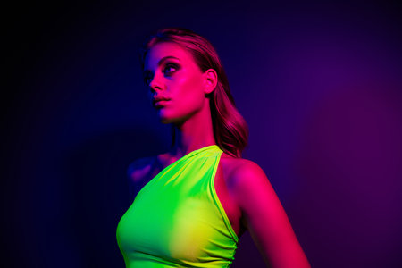 Portrait of a young woman illuminated by vibrant neon and ultraviolet lights, symbolizing style, beautyの写真素材