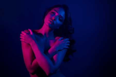 Portrait of a gentle Woman in Neon Lights Depicting Beauty, Elegance, and Sensual Charm with Modern Club Aestheticの写真素材