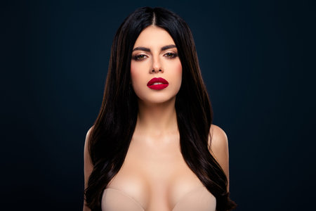 Elegant young woman with dark hair wearing lingerie, showcasing beauty and style against a dark backdropの写真素材