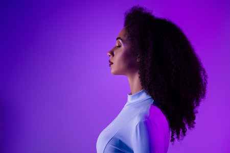 Profile of a Young Woman with Curly Hair in Futuristic Neon Lighting, Embracing Modern Fashion and...