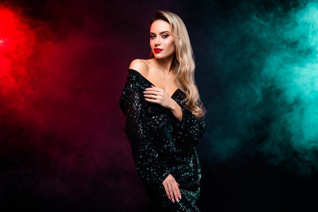 Young woman posing in a glamorous black sequined dress against a vibrant and colorful background