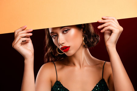 Chic and fashionable young woman posing confidently against a red background.