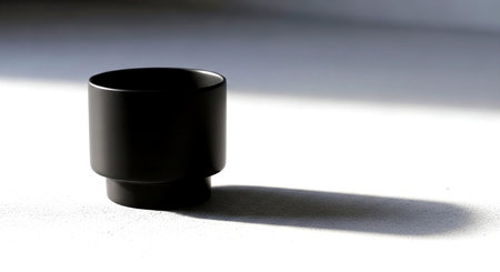 Black plastic cup on a white background with shadow. Close up.の素材