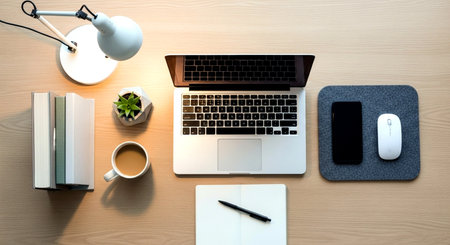 Top view of modern workplace with laptop, smartphone, coffee cup and other objects.の素材