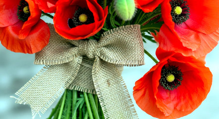 Poppies bouquet with ribbons on blue sky background.の素材