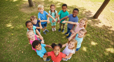 High angle view of children holding hands in park on a sunny dayの素材