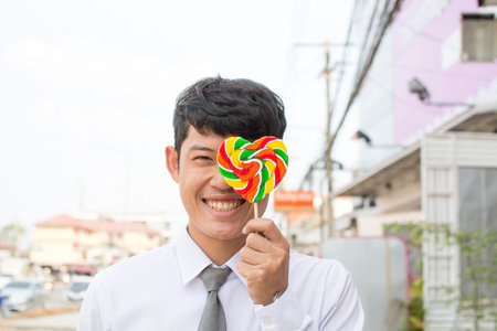 smiling asian boy and heart shape candy